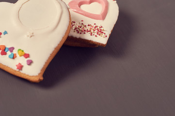 Gingerbread cookies in shape of heart with glaze on concrete surface. Concept of love or christmas. Toned and vintage image
