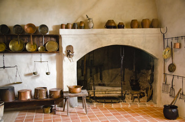 Interior of an old castle with fireplace and kitchen.