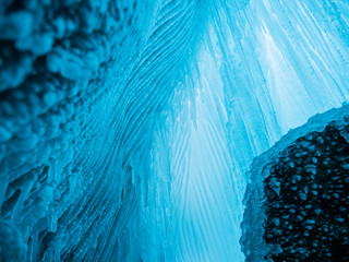Blue ice background. Ice stalactites stalagmites. The ice of lake Baikal