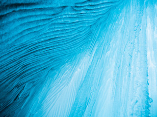 Blue ice background. Ice stalactites stalagmites. The ice of lake Baikal
