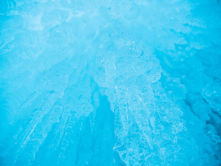 Fototapeta na wymiar Blue ice background. Ice stalactites stalagmites. The ice of lake Baikal