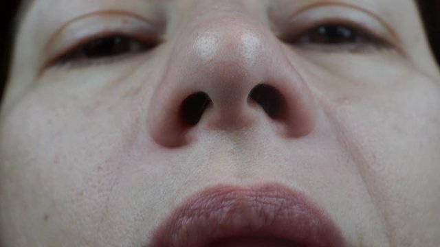 Macro Shot Of A Displeased Female Face Sniffing An Unpleasant Odor.