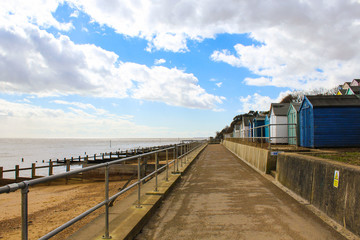 Naklejka premium walkway with beach huts next to the beach