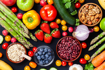 Concept of healthy food, clean eating. Organic fresh ingredients for cooking simple delicious vegetarian meal. Source of vitamins. Bright colors. Top view flat lay black background.