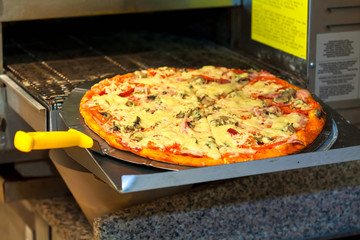 Cooking in a modern pizza oven at the pizzeria kitchen