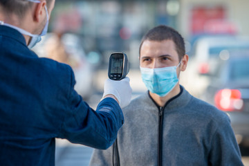 Temperature check at a supermarket of man, grocery store with thermal imaging camera. Image monitoring scanner to monitor the body temp of visitor customer