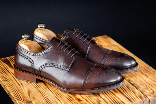 stylish leather brown shoes against a dark background.