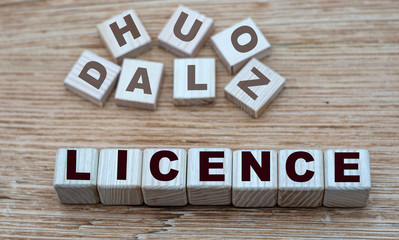 concept of the word LICENCE on cubes on a light wooden background