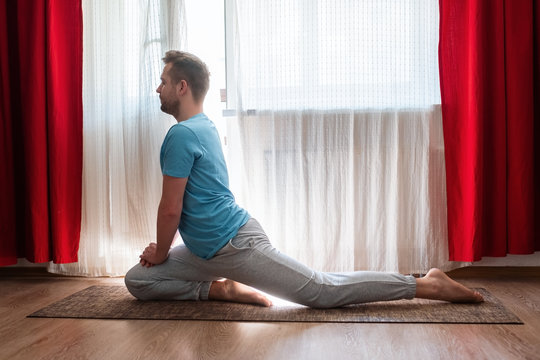 man doing asana one legged king pigeon or eka pada rajakapotasana