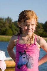 Rothaariges Mädchen mit nassen Haaren im pinken Badeanzug im Sommerurlaub am Meer
