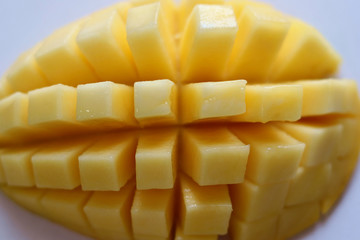 A closeup of sliced ripen and juicy mango on white background