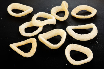 Snack onion ring  isolated over black background. Pile of crispy onion rings close-up as background