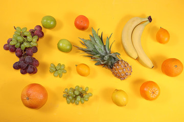 Tropical fruits, grapefruit, orange, lemon on a yellow background, healthy food, summer banner. The concept of minimal relaxation, detox diet. Place for text, flat lay.