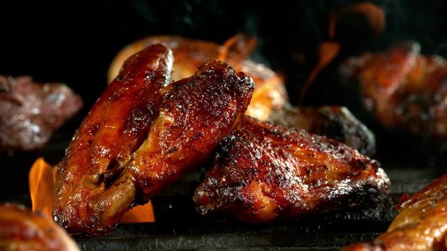 Super slow motion of chicken wings placed on grill. Filmed on high speed cinema camera, 1000 fps