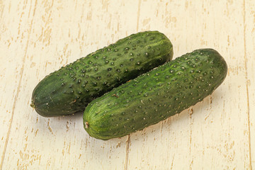 Green fresh cucumbers over background