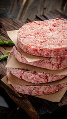 Organic frozen minced meat or beef cutlets on a wooden Board