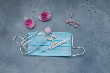 Medical mask, Medical protective mask, antiseptic, termometr and pills on blue background. Healthcare medical Disposable surgical face mask cover mouth and nose. Coronavirus quarantine