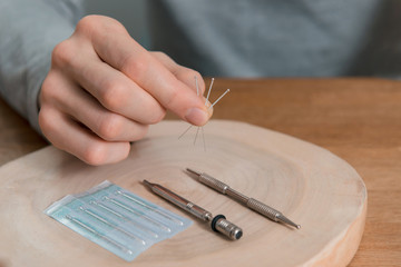 Acupuncture treatment on man's hands, needles.