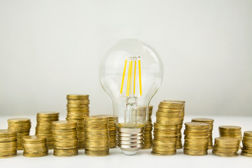 Business concept. Lamp with coins on a light background. Business ideas, brainstorming. Recovery and business growth. Copy space