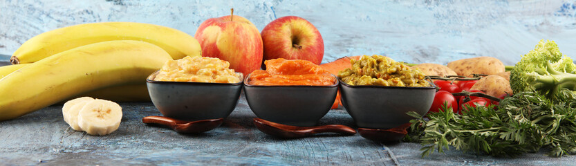 Bowls with baby food. Green, yellow and orange baby puree with fresh organic vegetables and juicy fruits