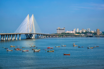 Mumbai skyline Bandra - Worli Sea Link bridge with fishing boats view from Bandra fort. Mumbai, Maharashtra, India - obrazy, fototapety, plakaty