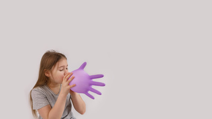 Young sad girl play with protective medical glove. Teenager with glove inflated like balloon. Quarantine, self isolation, depression, social distance, mental health concept. Stock photo.