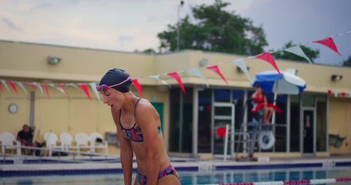 Female swimmer getting out of pool