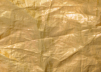 Crumpled gold fabric background close up. Textile and texture concept. Copy space.
