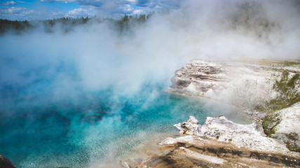 Turquoise hot spring in Yellowstone National park, United States, Wyoming. Geothermal landmark with blue shade of water and steam. Travel background as for memory card from vacation. 