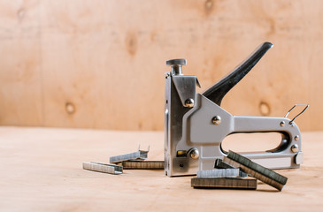 A building stapler on the wooden background