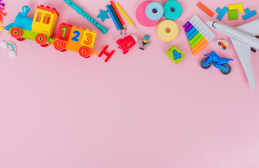 Frame of kids plastic toys on pink background with blank space
