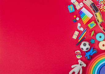 Kids plastic and wooden toys on red background