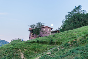 Paisaje de casa con la luna de fondo