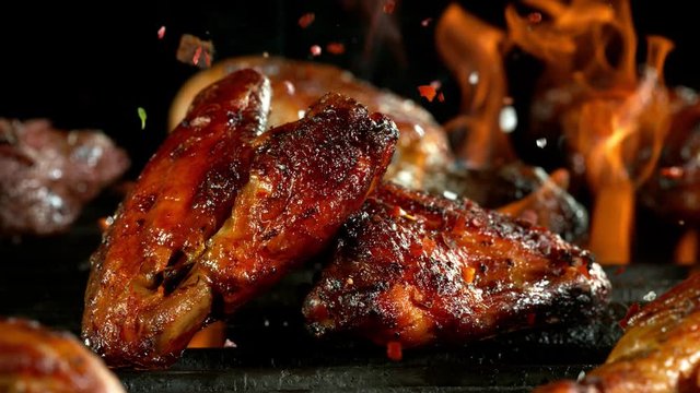 Super slow motion of chicken wings placed on grill. Filmed on high speed cinema camera, 1000 fps