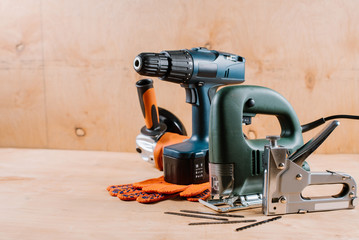 Electric building and crafting instruments and tools on the wooden background