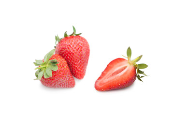 Ripe fresh organic strawberries and half a strawberry with leaves isolated on white background