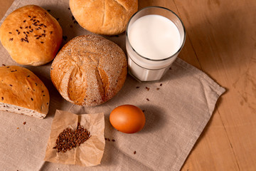 Glass of milk, eggs, and homemade bread on the wooden table. with copy space for text