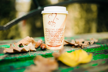 cup of coffee in autumn atmosphere with foliage and acorns