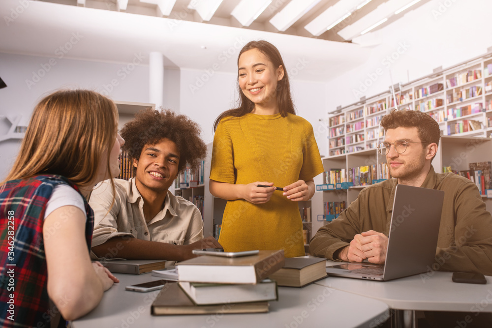 Poster university students are studying in a library together. concept of teamwork and preparation