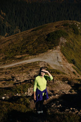 Naklejka na ściany i meble Female trail runner enjoys the view in mountains