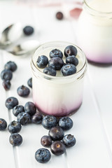 White fruity yogurt in jar and blueberries.