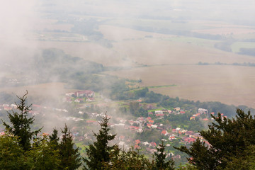 View of the town of Bystrice pod Hostýnem in the Czech Republic from a local lookout tower. The landscape is in the fog.