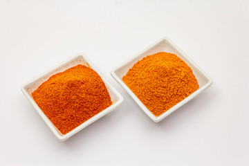 Two types of Hungarian paprika powder, hot and sweet, isolated on white background