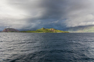 A mystical fjord in Norway with mountains and fog hanging over the water in polar day. midnight sun, selective focus