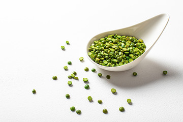 two types of legumes, beautifully arranged in cups and on a white background - green peas and orange lentils. Top view. copy space. Vegetarian food.