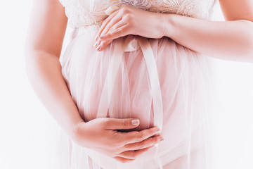 Pregnant belly on a white background. Tender pregnancy.