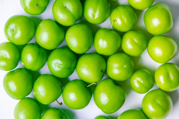 green plums on white ground