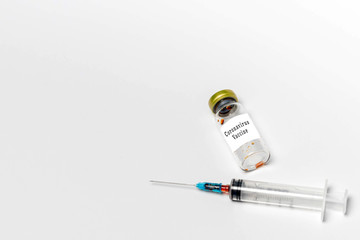 Used medical vial with Coronavirus vaccine and hypodermic syringe isolated on white background. Banner, top view, copy space