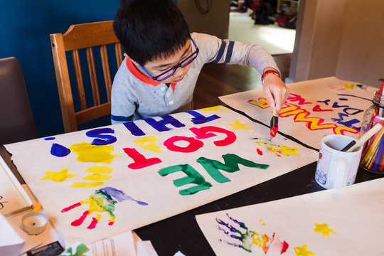Boy painting signs of encouragement during quarantine