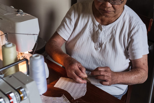 Grandma tying thread on cloth face mask